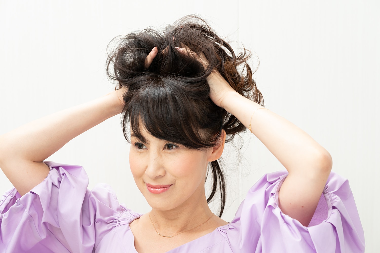 髪の毛の中間から毛先に向けて持ち上げるようにワックスをもみ込む。