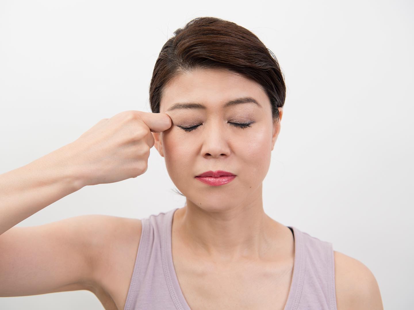 目尻を指圧している女性