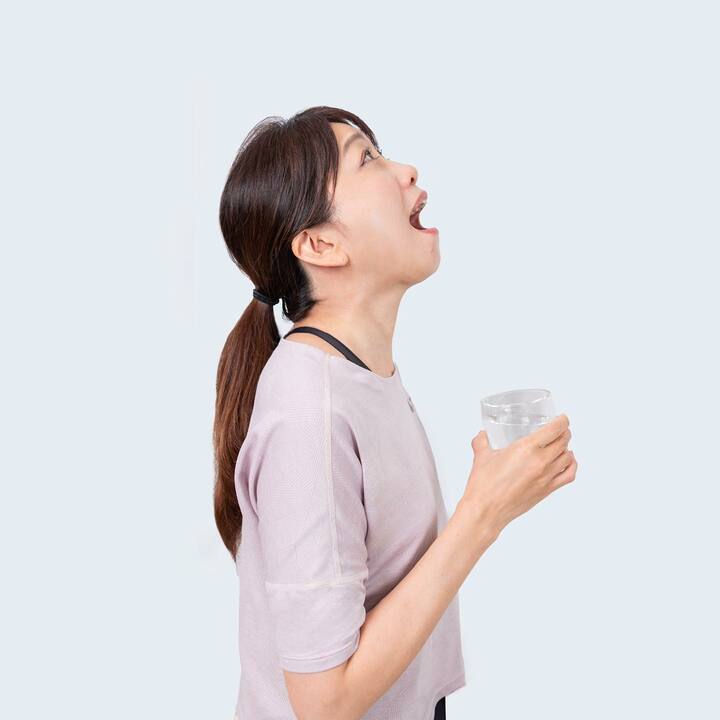 カーッと息を吐きながらうがいをする