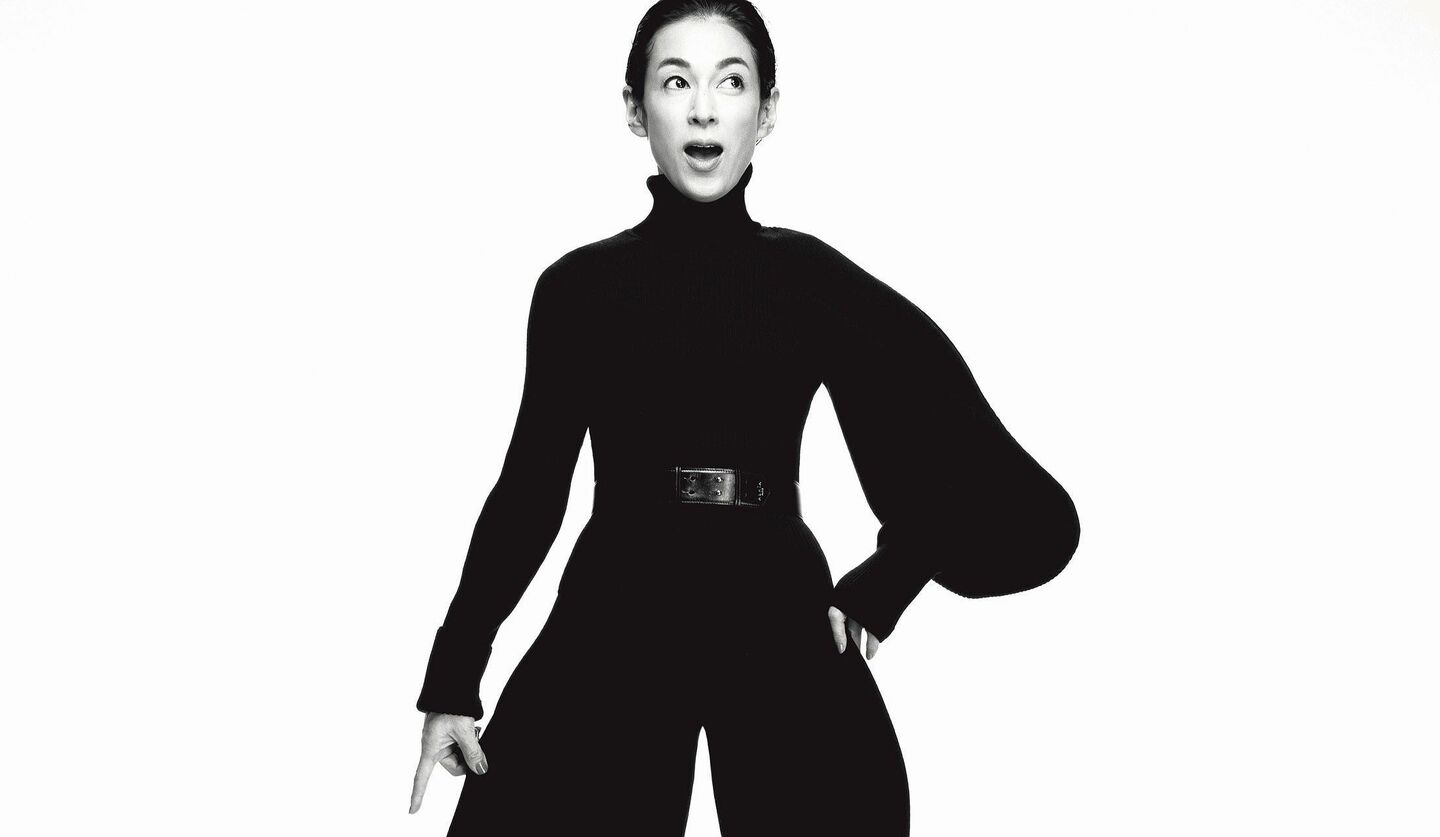 アシンメトリーな袖の黒タートルを着た鈴木保奈美さんの白黒写真