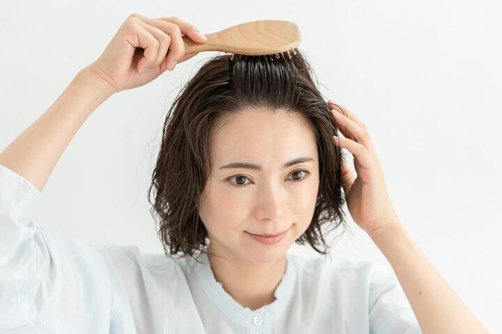 頭皮用ブラシでオールバックにブラッシングして髪の根元を起こす。
