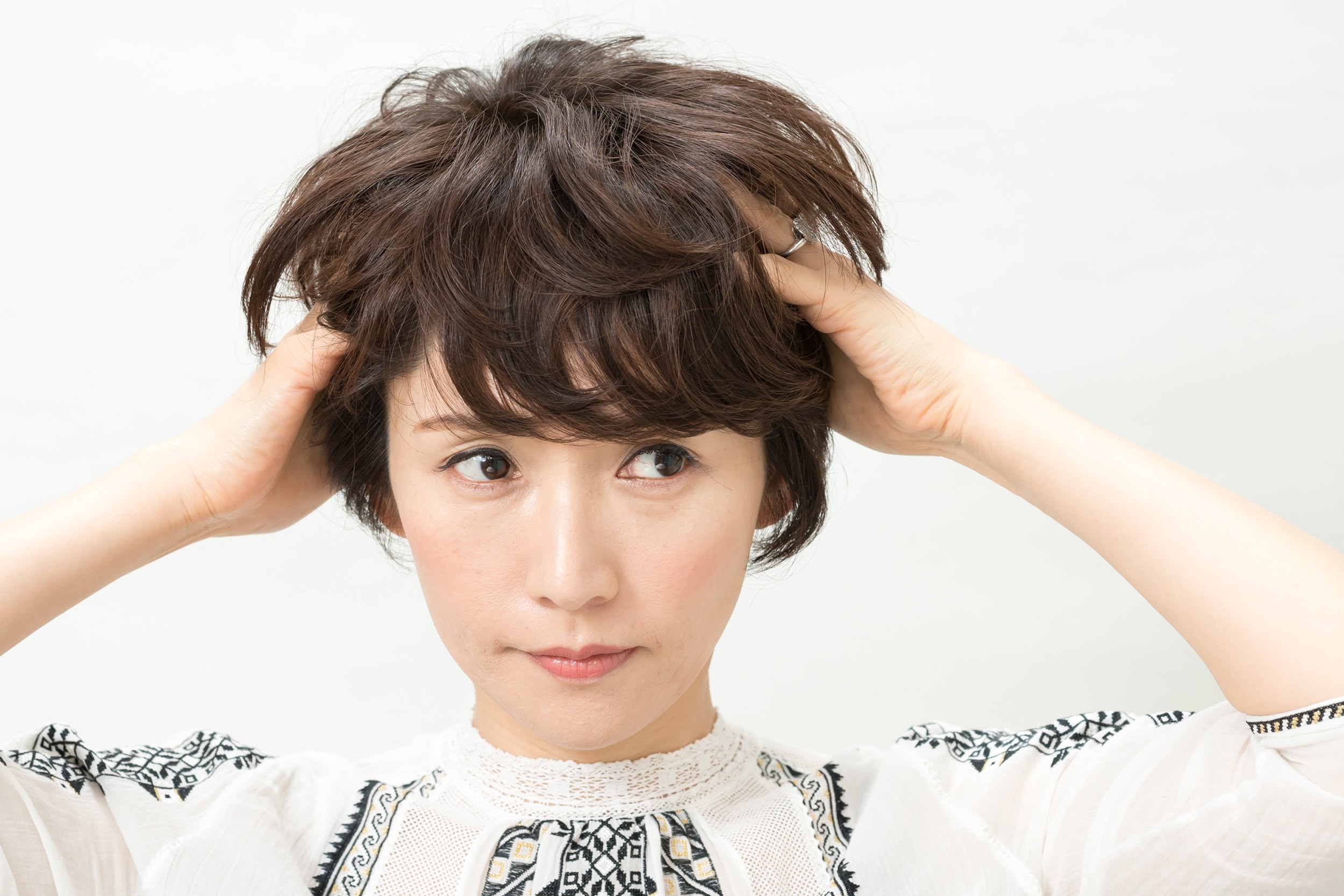 パール粒大ふたつ分のワックスを根元にON。根元にワックスをもみ込まないと髪が立たないのでしっかりともみ込んで。
