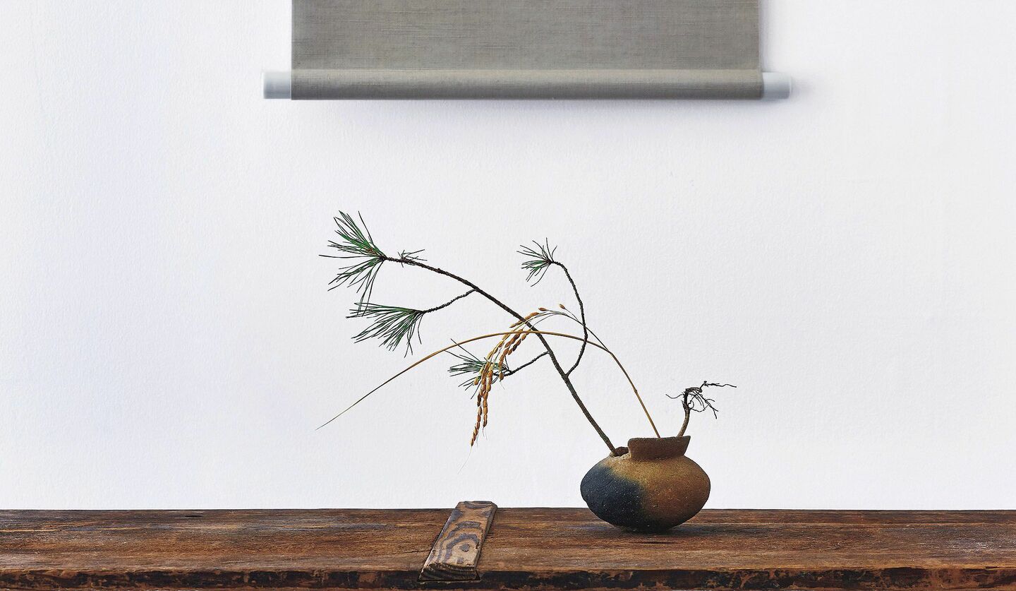 和テイストの花瓶に稲穂と松が飾られた写真