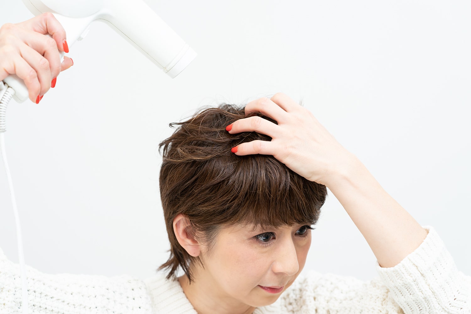 つむじからフロントへ向けて熱風を当てる。指の腹で地肌をこするように左右へ髪を振る。