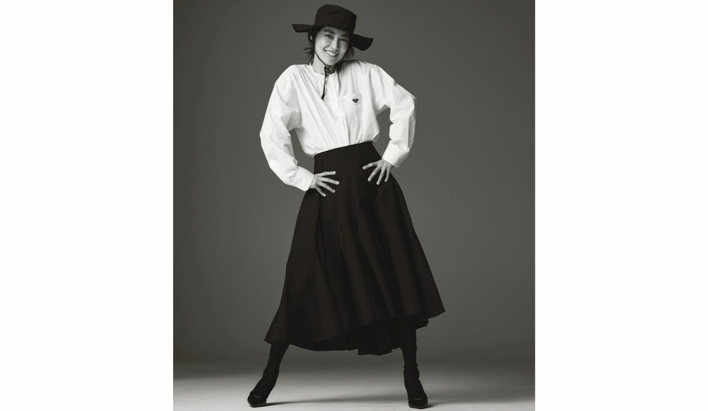 菊地凛子さんが着る「プラダ」白シャツに黒のロングスカート、黒帽子コーデ写真