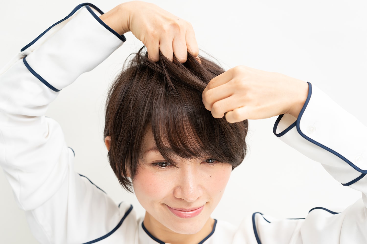 トップが潰れないように握りながら、毛先はつまんで束感を出す。