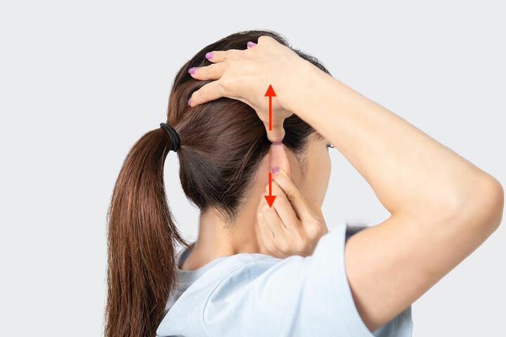 側頭骨を持ち上げながら、耳を下に引っ張る