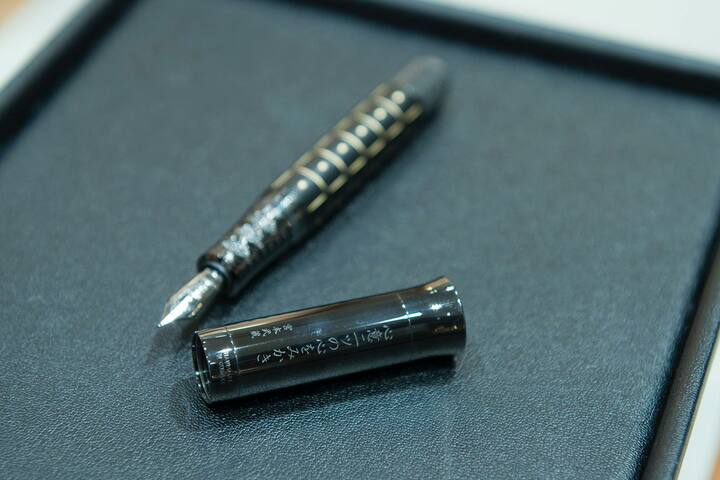 「心意二ツの心をみかき」の文字が刻まれたキャップ