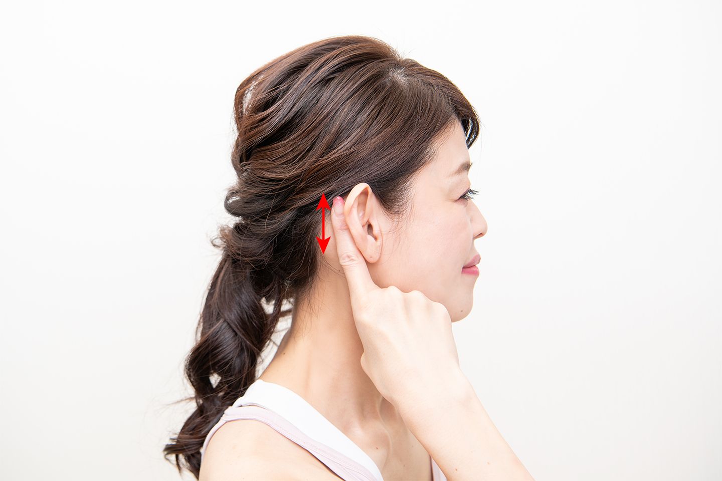 耳の後ろを縦方向にさすりながらほぐす