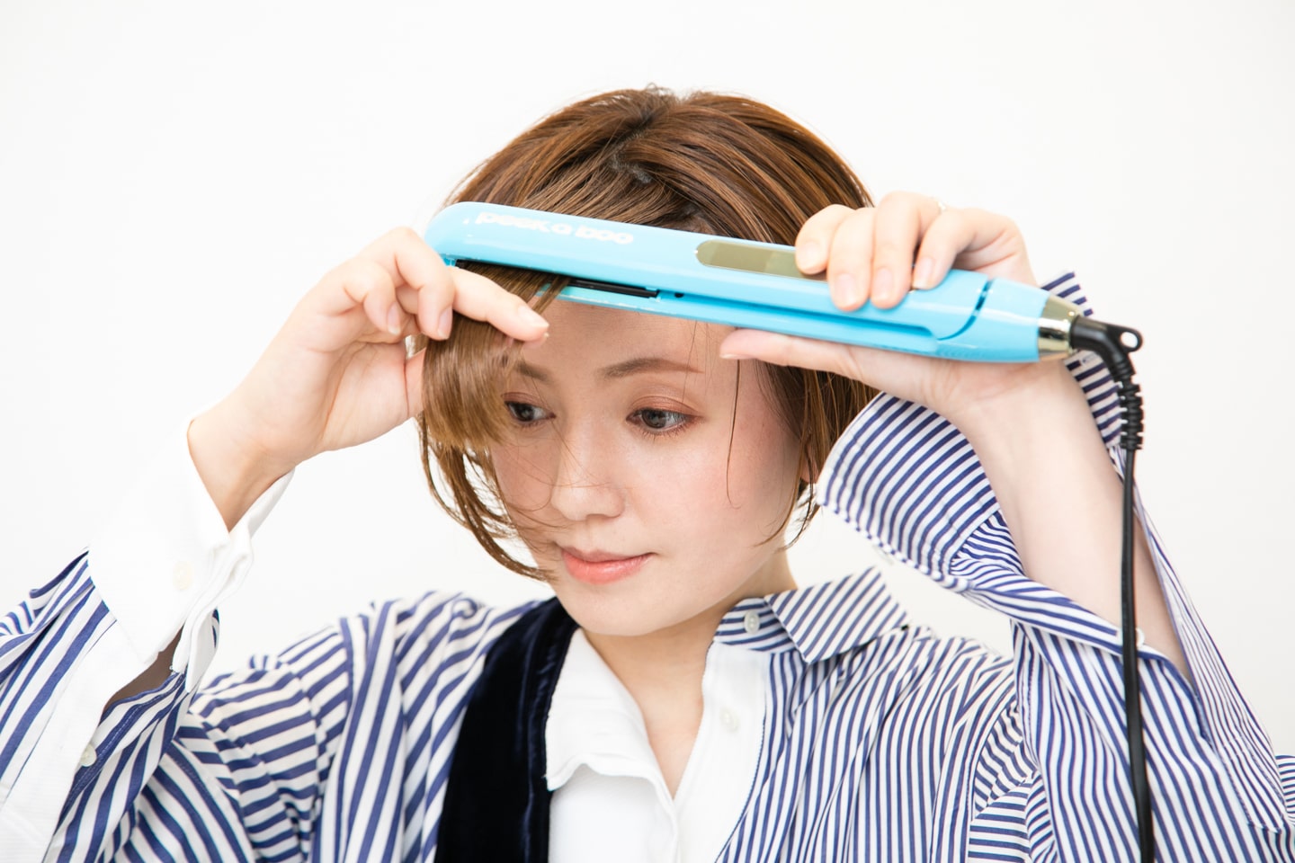 全体の表面の髪を、ストレートアイロンで中間から挟んで毛先まで滑らせる。サイドのボリュームを抑え、ツヤを出す効果がある。