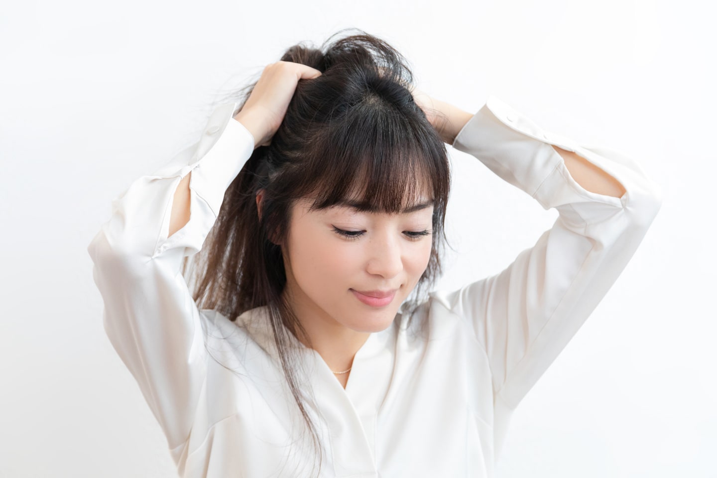 保湿力とツヤが出るヘアオイルを手のひらにのばし、髪全体にもみ込んでなじませる。