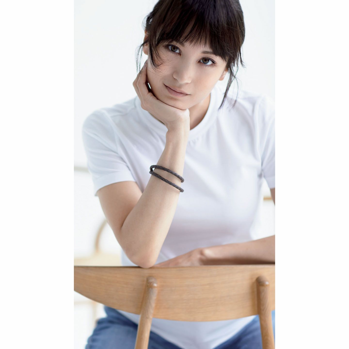 ブルネロ クチネリの「定番白Tシャツ」。ストレッチのきいたやわらかな肌触りと美しい光沢が格別。希少価値の高い超長綿を紡いだ生地は、強度にも優れ、毛羽立ちが最小限に抑えられています。後ろの襟ぐりにさりげなく並ぶ細いボールチェーンのあしらいも見事。細部にいたるまでブランドの矜持が感じられる一枚です。「定番白Tシャツ」¥44,000・デニム¥120,000(ブルネロ クチネリ ジャパン) ブレスレット/私物