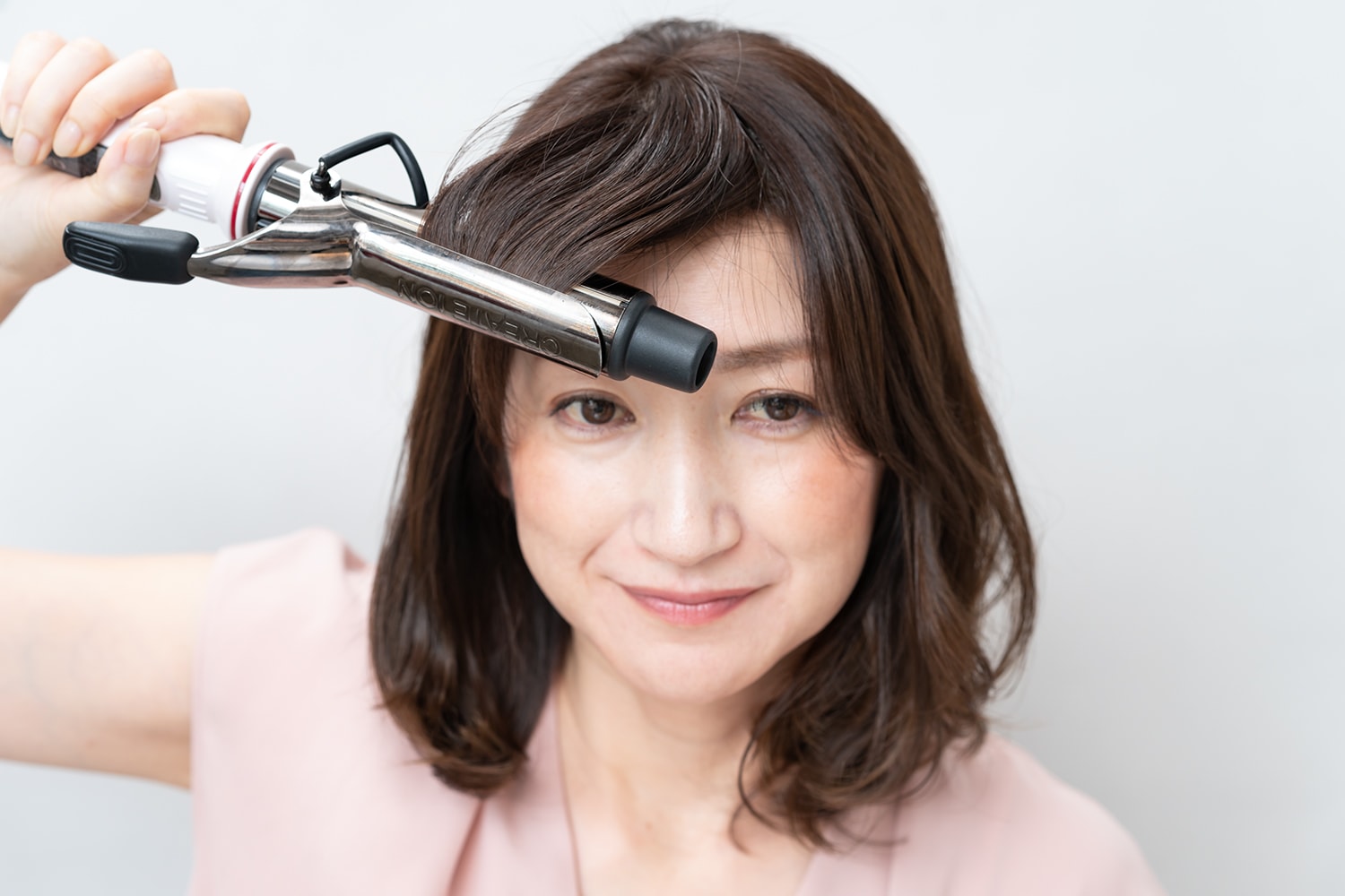 流したい方向の逆に引っ張りながら前髪を巻くと毛流れが整い、割れにくくなる。