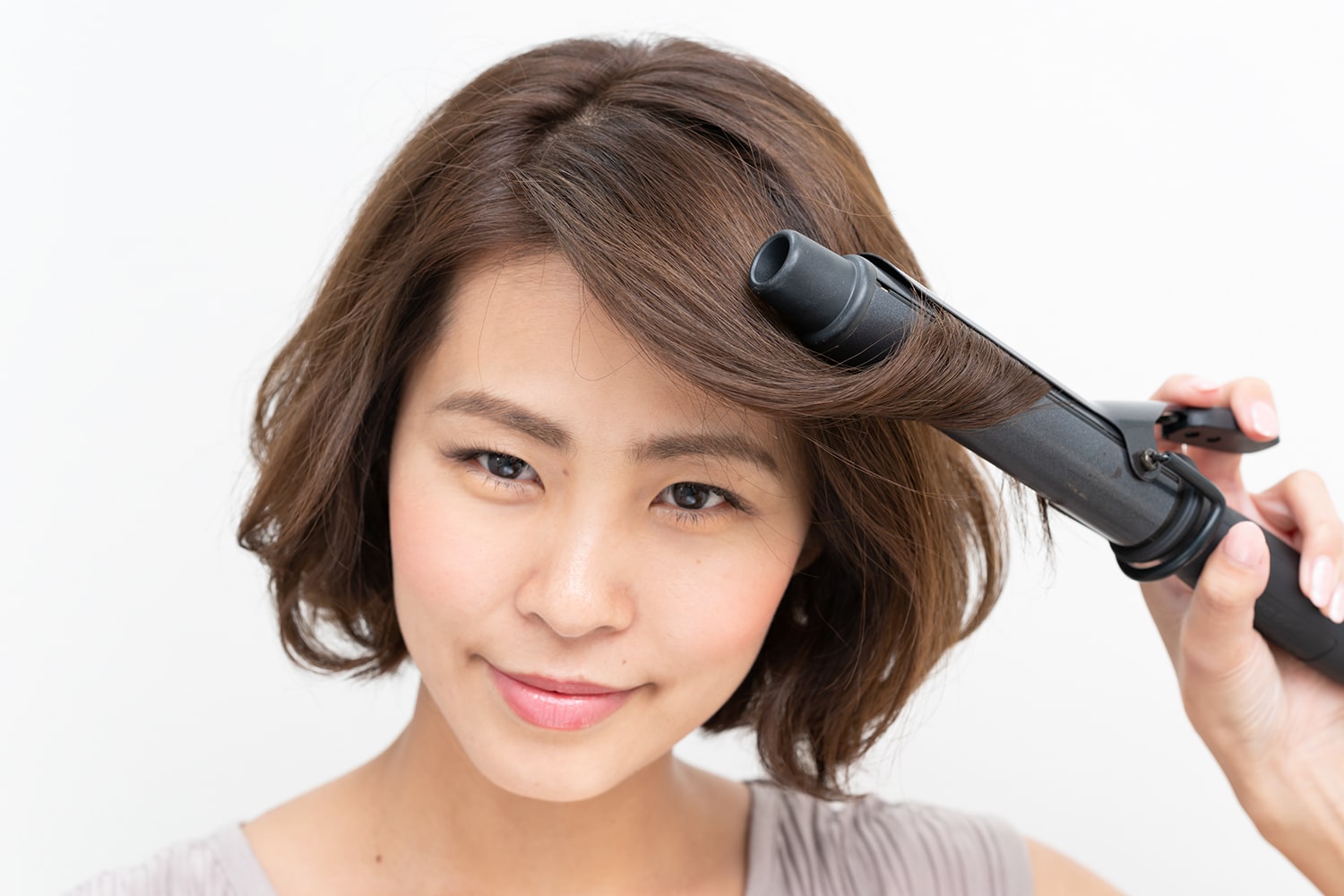 コテは32ミリを使用。毛先だけワンカールするのがコツ。逆サイドも同様に。