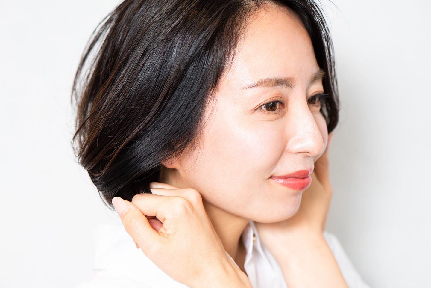 手に残ったバームを、耳後ろの髪の根元からリバースになじませ、タイトに仕上げる。