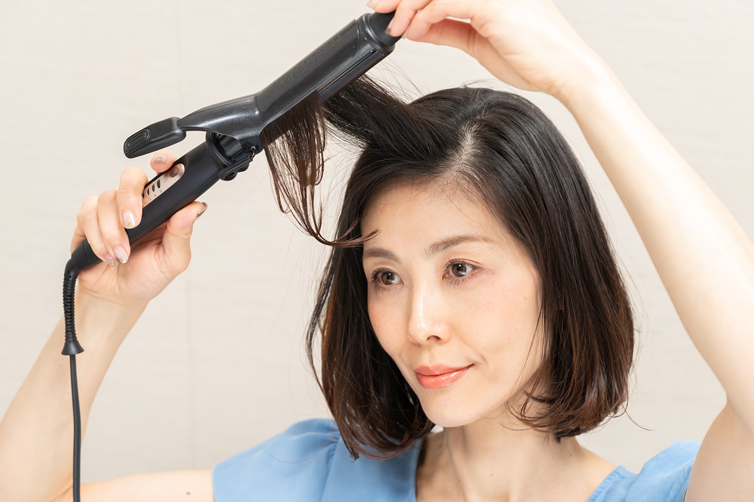 前髪は毛束の中間から毛先に向けて内巻きに。コテを毛先に滑らせるようなイメージで通す。
