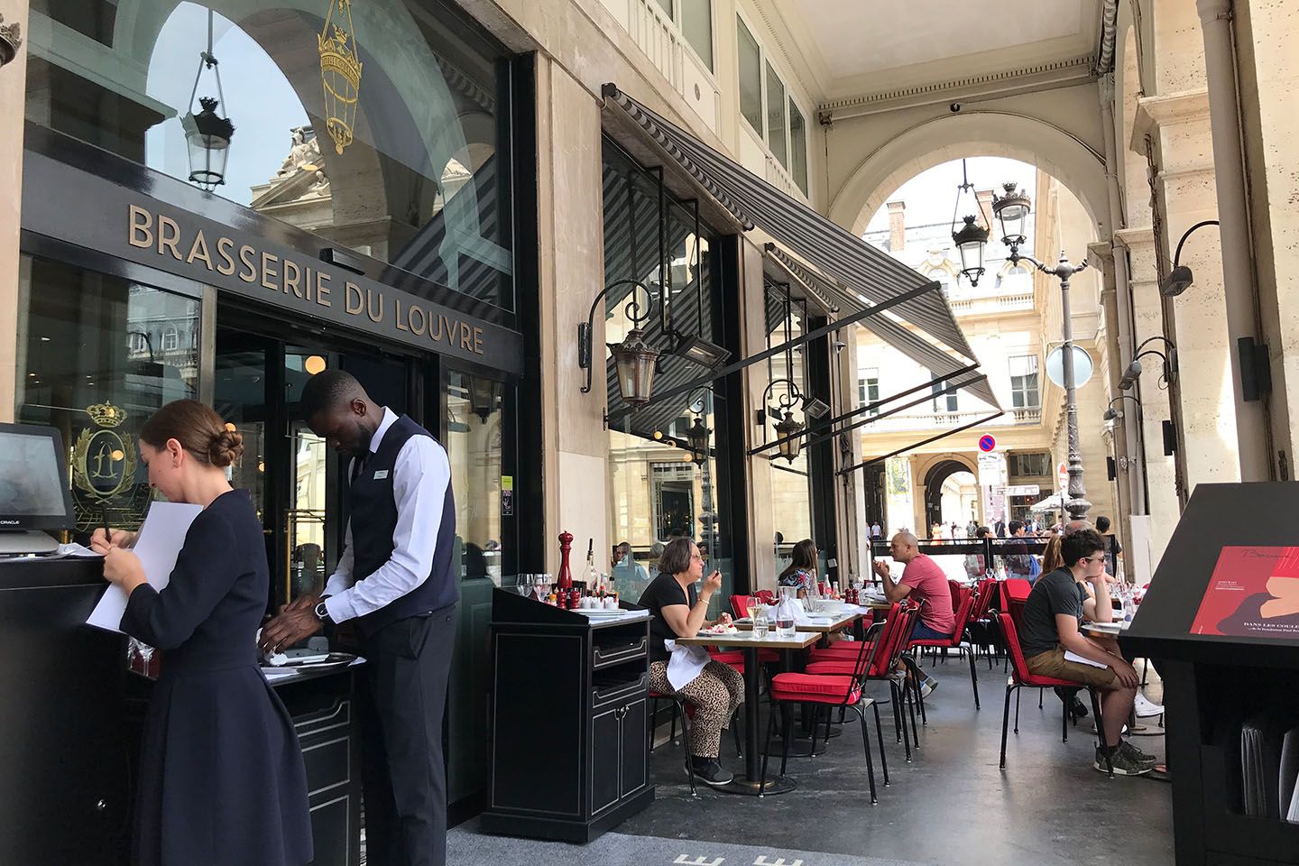夏はテラス席が人気だ。向かいにはフランス王立の劇場コメディ・フランセーズやパレ・ロワイヤルという歴史的建築物が立ち並ぶ絶好の立地。