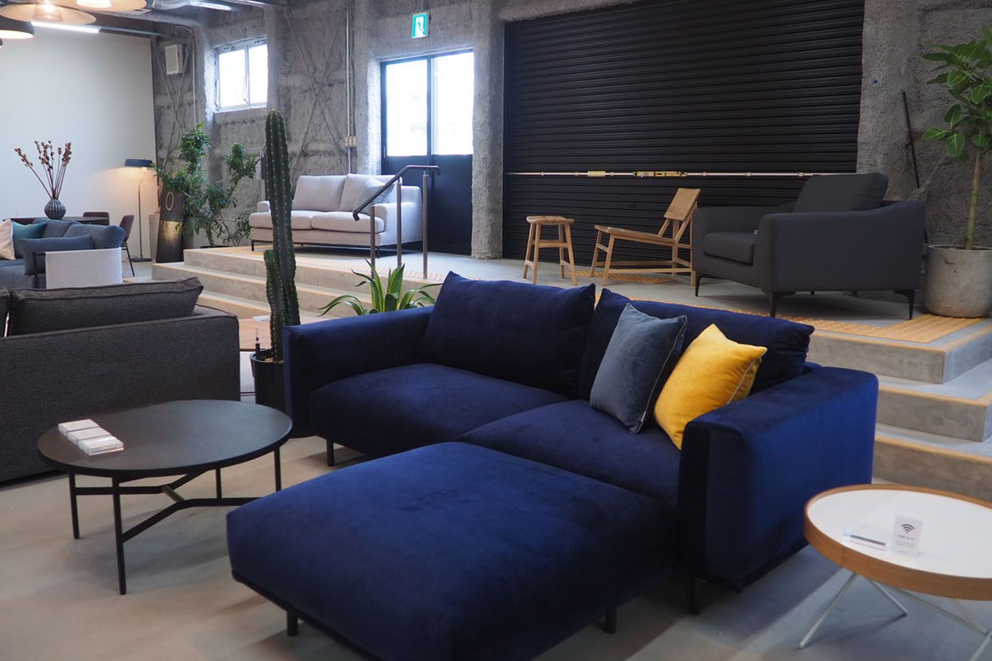 部屋のイメージをぐっとモダンにするネイビーのソファー。フェデーレソファ ネイビー¥203,704・オットマン¥55,556