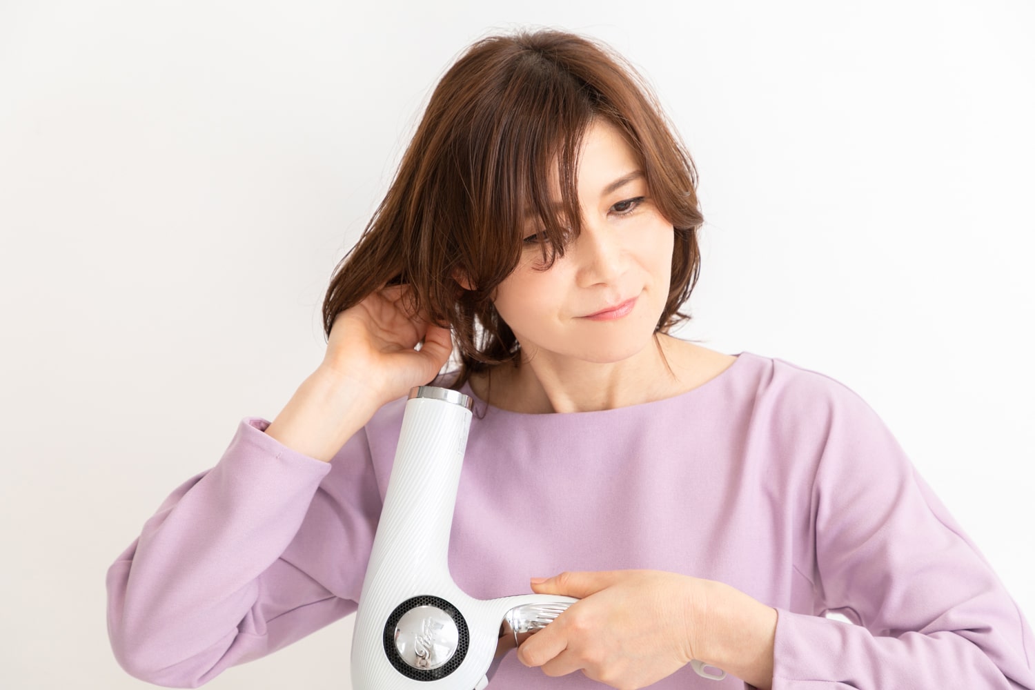 下から手ぐしを入れながらドライヤーの風を当てて、空気を入れるように根元を起こしてブロー。