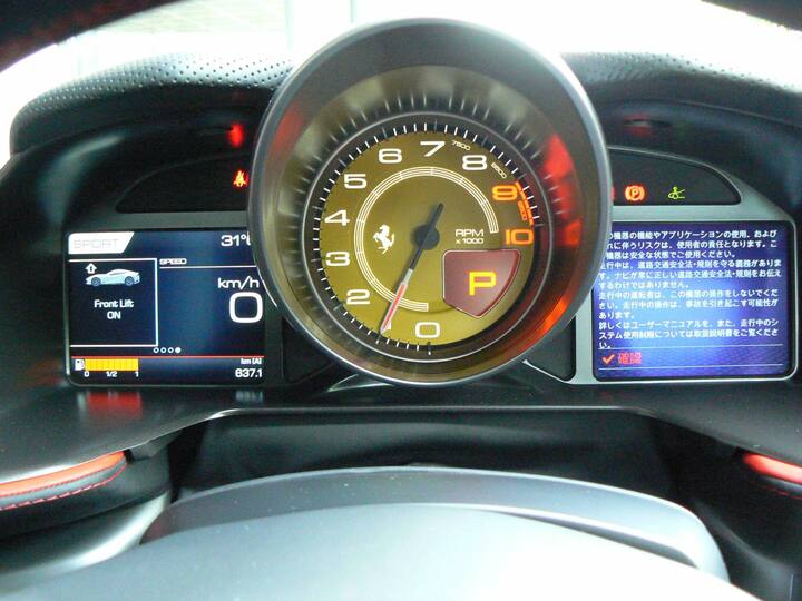 タコメーターを中央に配した、スポーツカーらしいレイアウト。右の説明書きが表示された部分は、カーナビのモニターでもある。