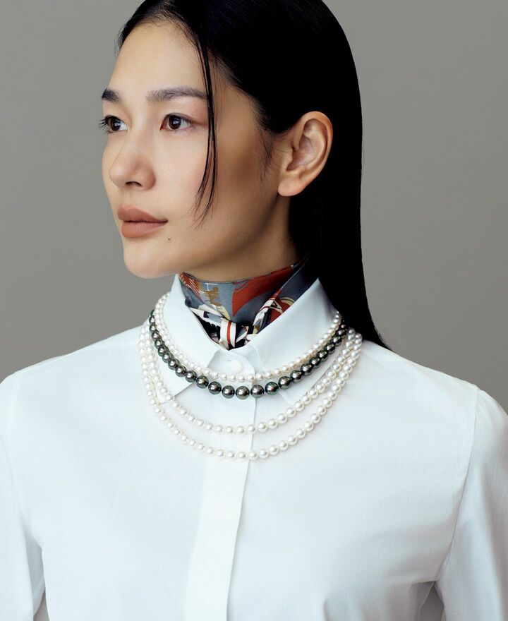 スカーフとパールネックレスをレイヤードしたモデルの大塚まゆかさん
