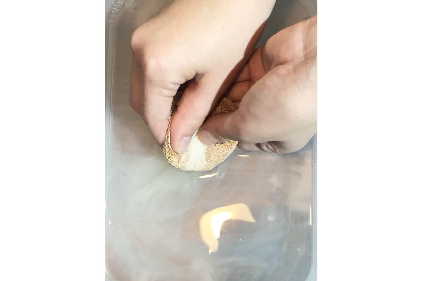 パフにクリーナーをのせ、汚れになじませたらぬるま湯で押し洗いを