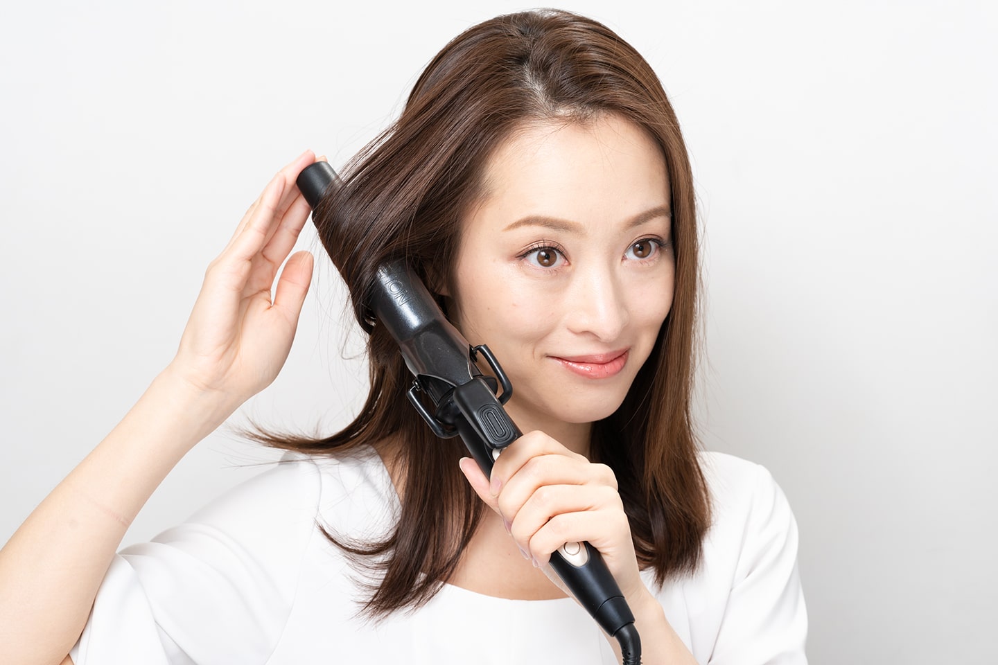 耳より前の毛束とそのすぐ後ろの毛束と2回に分けてリバース巻きに。