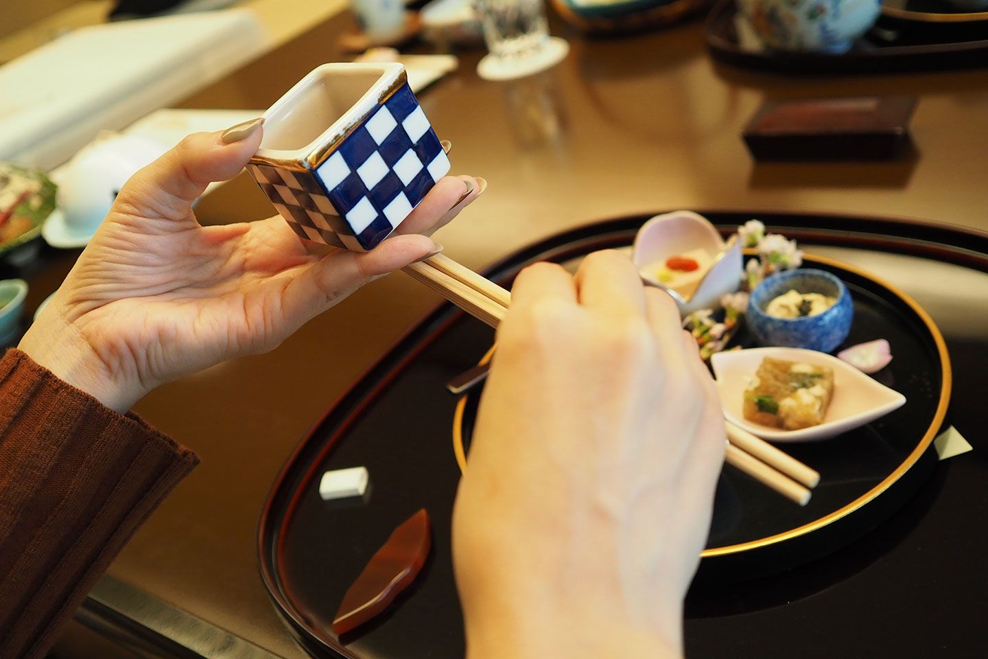 器を持った左手の中指(持ちやすい指でOK)で、箸を挟んで支えます。