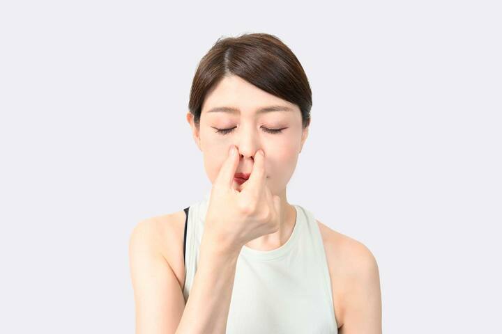 右手の親指と人さし指で左右の小鼻の付け根の下側をつまむ
