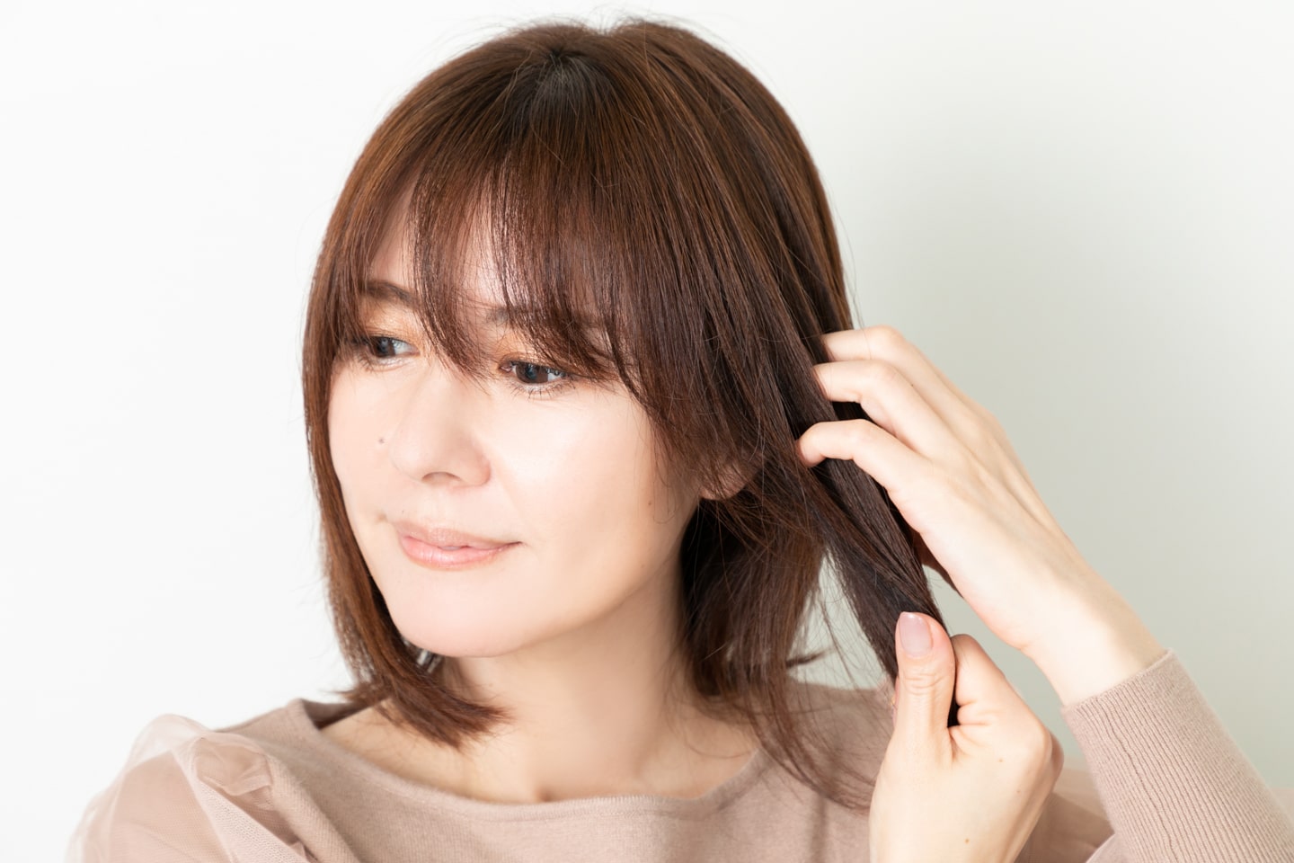クリームを両手のひらに広げ根元から中間にかけて手ぐしでとかしながらなじませる。