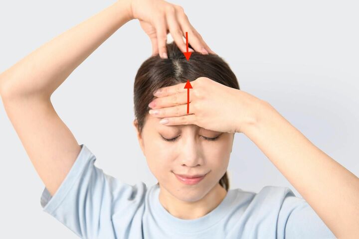 左手を額に置き、右手で頭頂部を押さえて寄せ合う