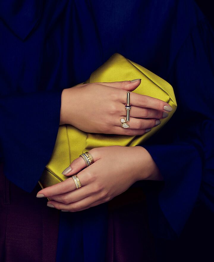 「ロド」のクラッチバッグと「ブシュロン」のジュエリーを纏った女性の手元