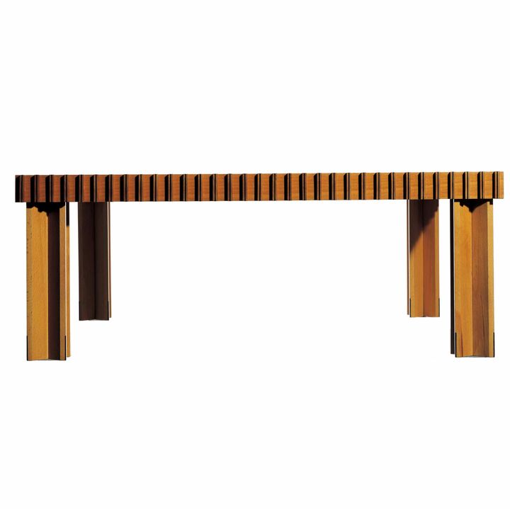 金具を一切使用せず、木材のはめ込み技術のみで完成した圧巻のコーヒーテーブル『Kyoto』は、1974年に誕生。写真右奥は、87歳にして現役の木工マエストロ、ピエルルイジ・ギアンダ氏。これまで木製のブックマークやダストボックス等々、数えきれないほどの「名品」を世に送り出してきた。すべての商品に刻印された樫の木のアイコン（写真左）は、ギアンダ＝樫の木に由来。ビーチ材＋黒檀［高さ350×横900×奥行き900㎜］￥1,200,000（カッシーナ・イクスシー青山本店〈ギアンダ〉）