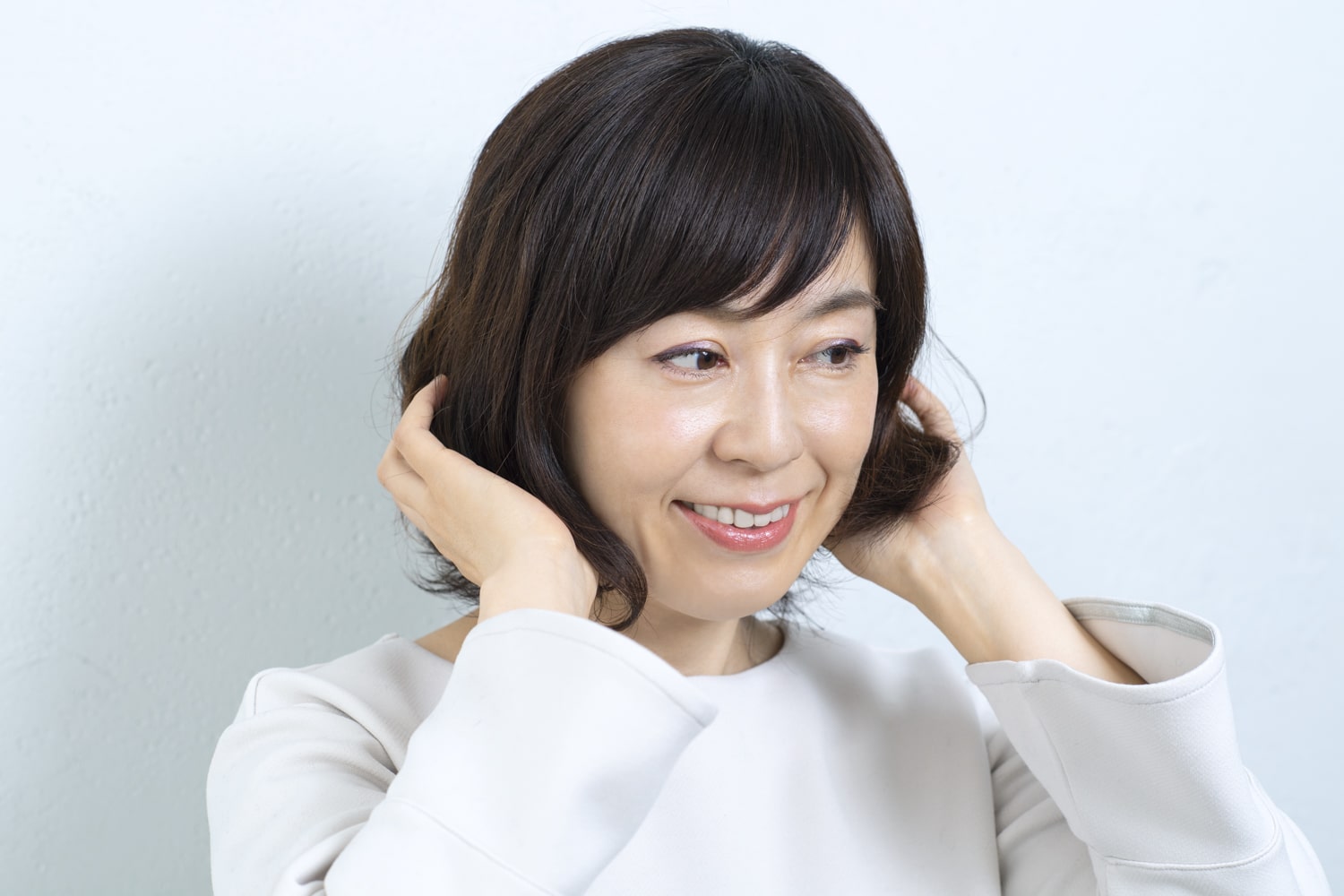 トリートメントムースを、ハチ下の髪の毛先中心に揉み込んでパーマを戻す。