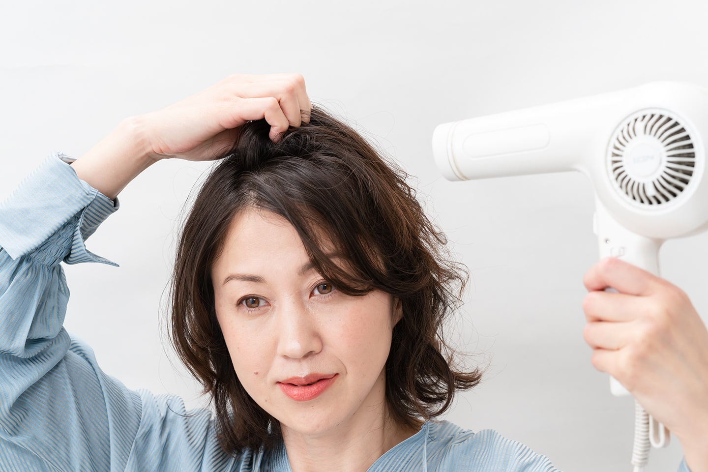 ドライヤーは弱風。根元の立ち上げたい部分と平行になるように風をあてる。