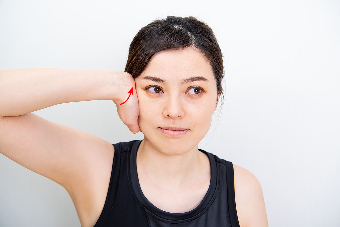 手を真横にして、手のひらで頬骨を押さえる