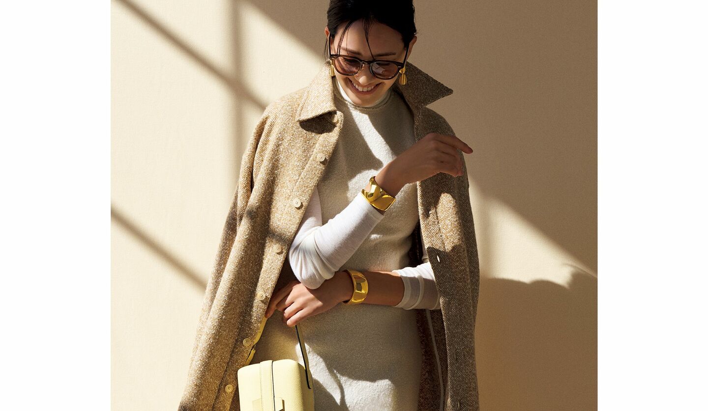 ホワイトのワンピースとツイードアウターを着用したモデル