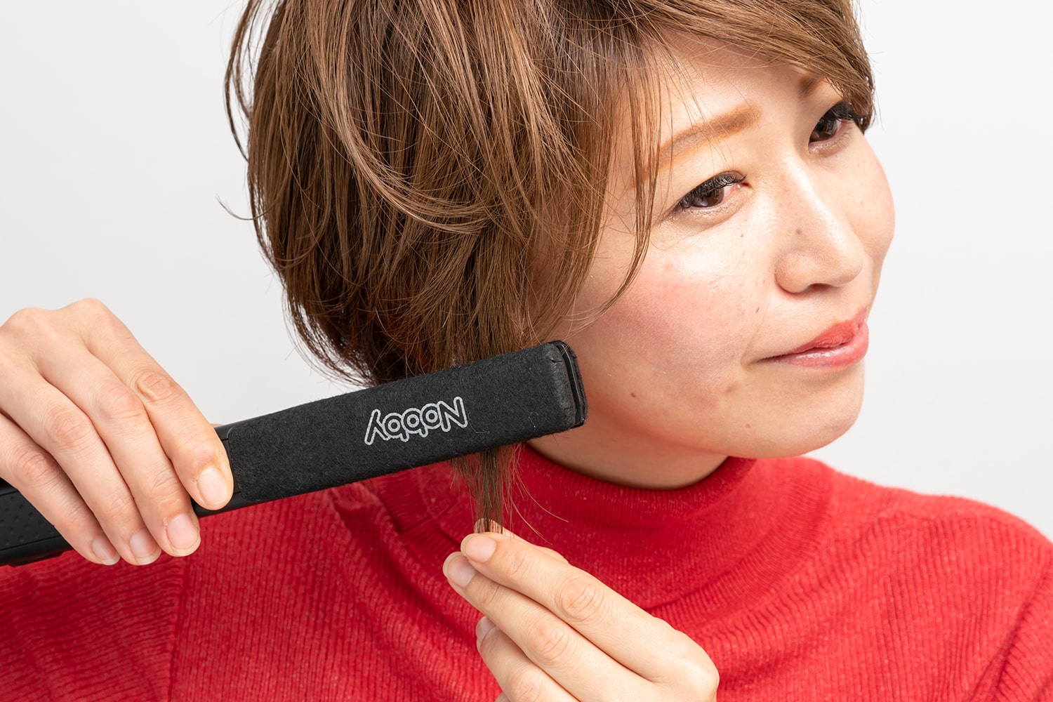 毛束の中間から毛先に向かってアイロンを通す。毛先だけ内巻きにすること。