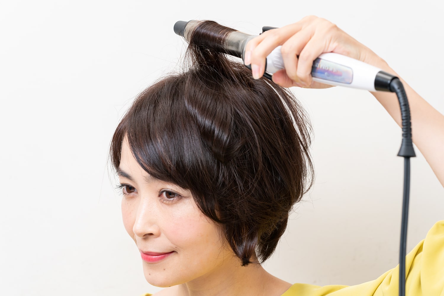 つむじ後ろの毛束も毛先から根元までしっかりと巻き込む。フロントではなく、後頭部の方へ巻くのがポイント。