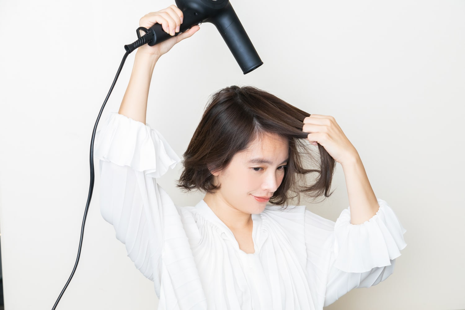 ハチ上の髪は、上に持ち上げながら、前に向かって乾かす。根元を前に向かせることで、ボリュームが出る。サイドは、前から風を当てて、うしろに向かって乾かす。