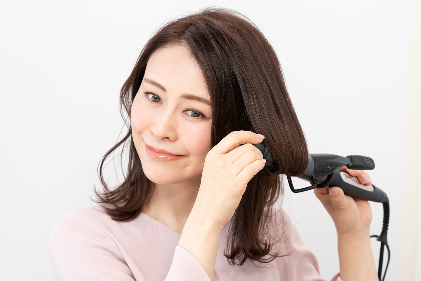 毛先からカールアイロンに1.5周内巻きにする。