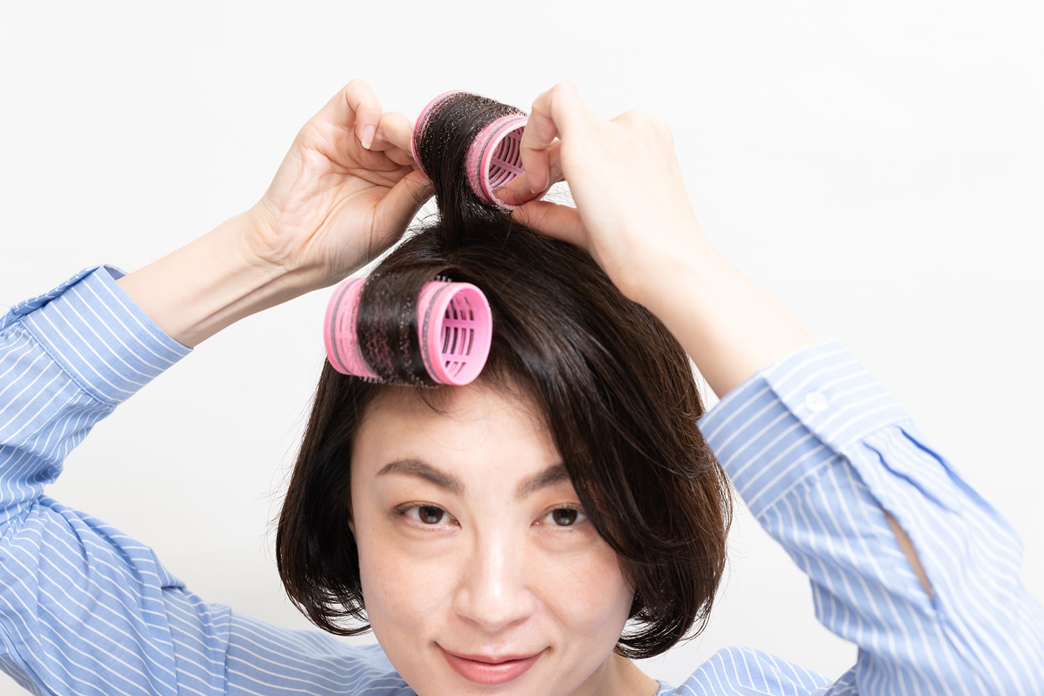 前髪は短い髪だけ。トップは分け目の毛流れに沿わせるように巻くのがポイント。正面から見たときにカーラーが横向きになっていればOK。
