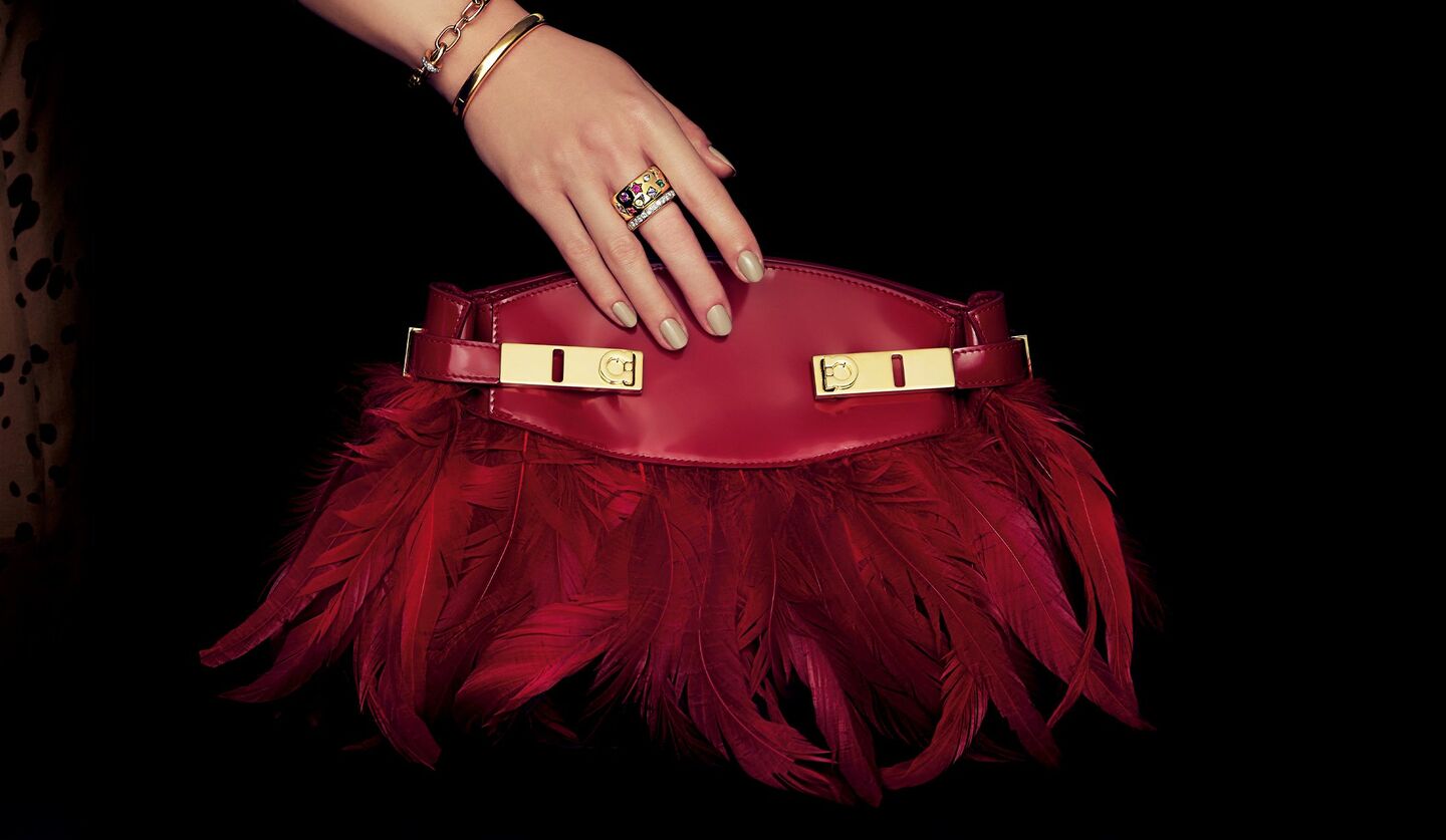 「フェラガモ」のバッグと「ポメラート」のジュエリーを纏った女性の手元