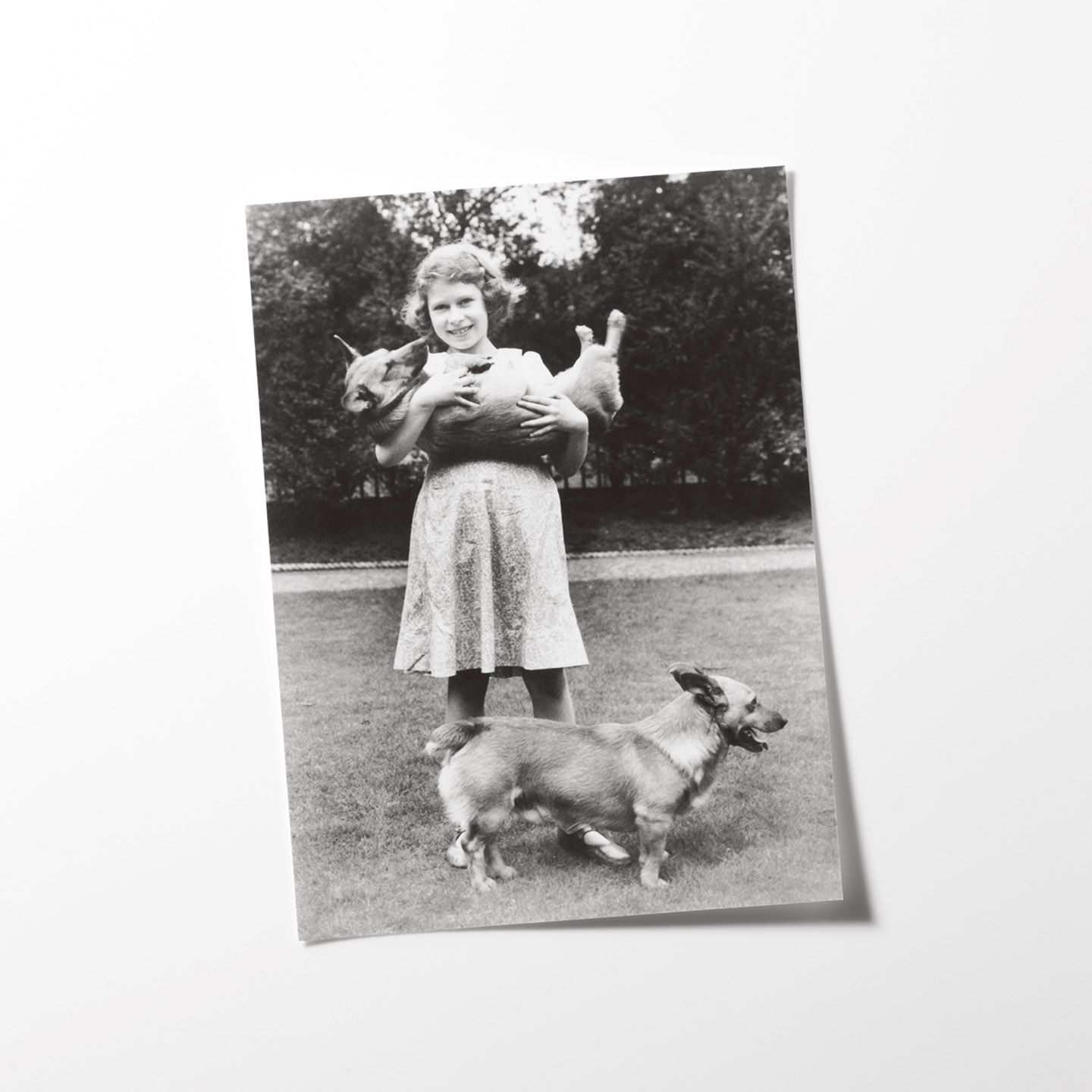 1936年、自宅の庭にて。幼少期から、たくさんの犬に囲まれて育った女王。初めて飼ったコーギーの名前は、「デューキー」©Getty Images