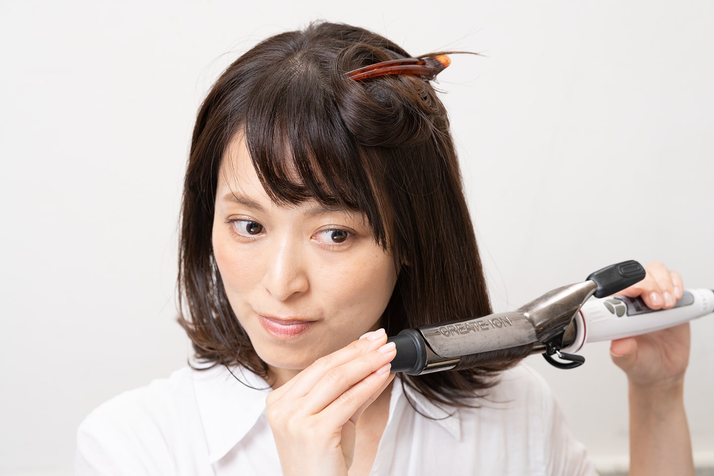 毛束の中間あたりから毛先が外はねになるように滑らせる。