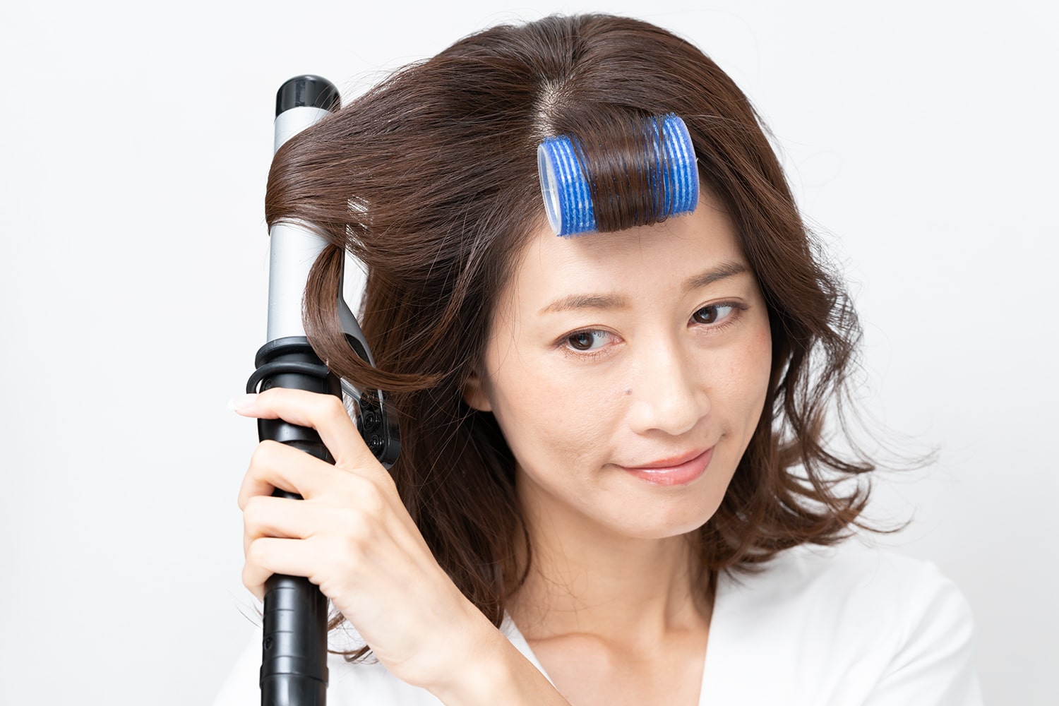 コテは32mmを使用。毛束の中間だけを巻くのがコツ。カールがついたら毛先に向けてすべらせるようにコテを抜いて。