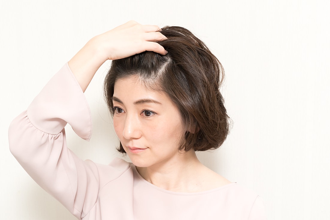 指で髪をちらす