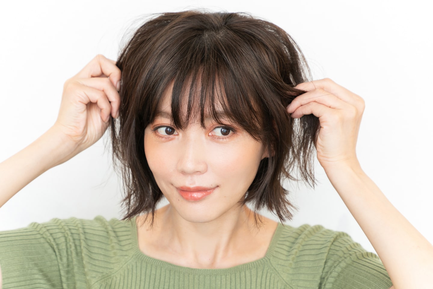 手のひらに余ったスタイリング剤はサイドへ揉み込む。空気感が出るように、毛束を握るイメージでつけるのがポイント。