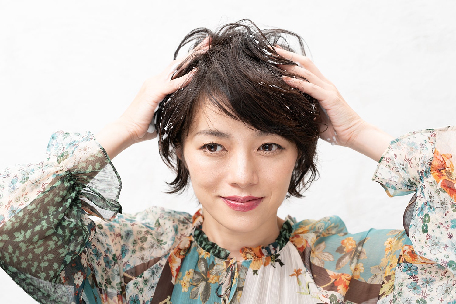 髪の表面を持ち上げるように握りながら、泡を置くようなイメージでつける。ムースはすべてつけず手のひらに残して置くのがポイント。この時点ではまだもみ込まない。