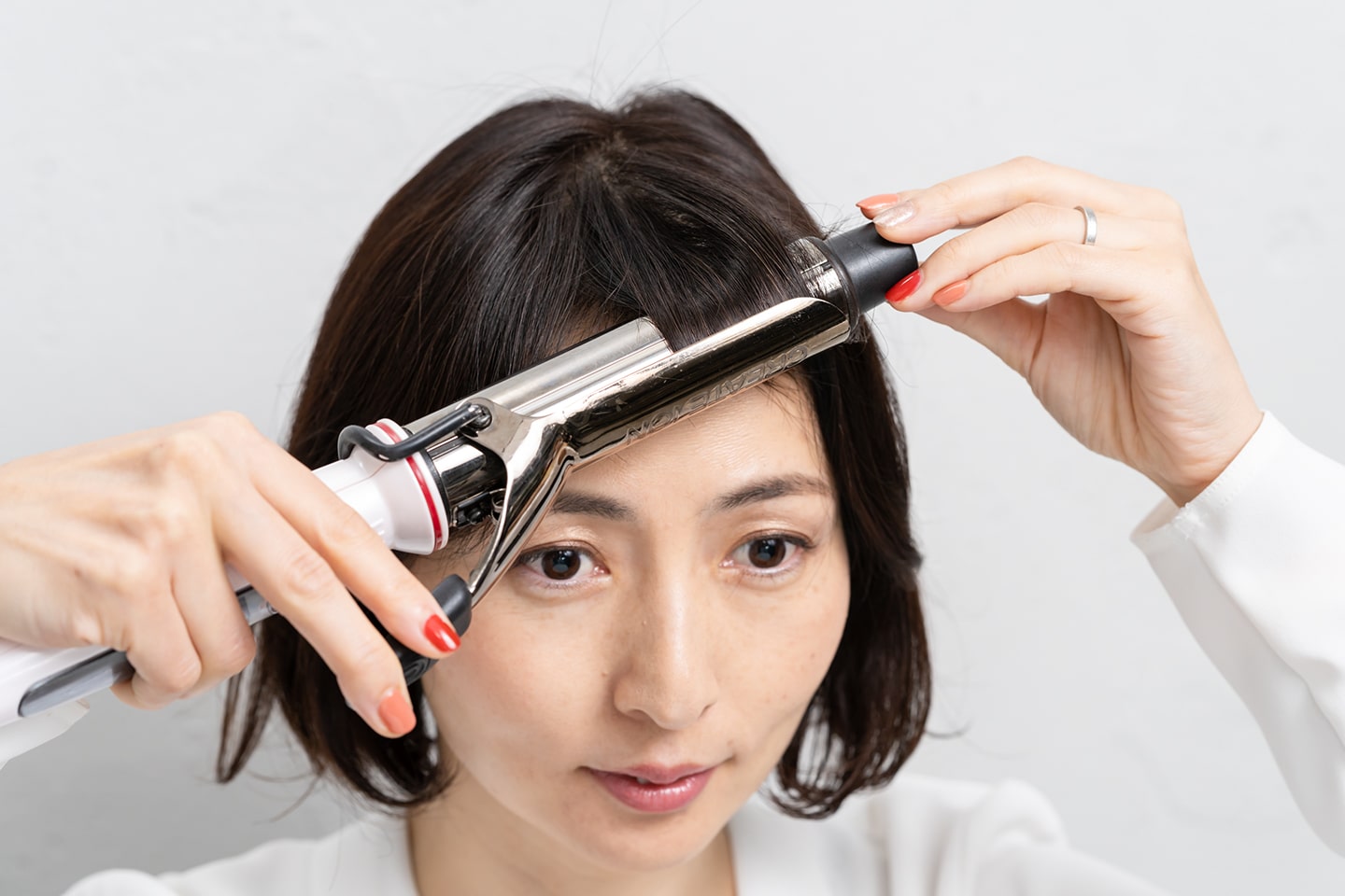 分け目の毛流れに合わせて斜め前に軽く引っ張ること。